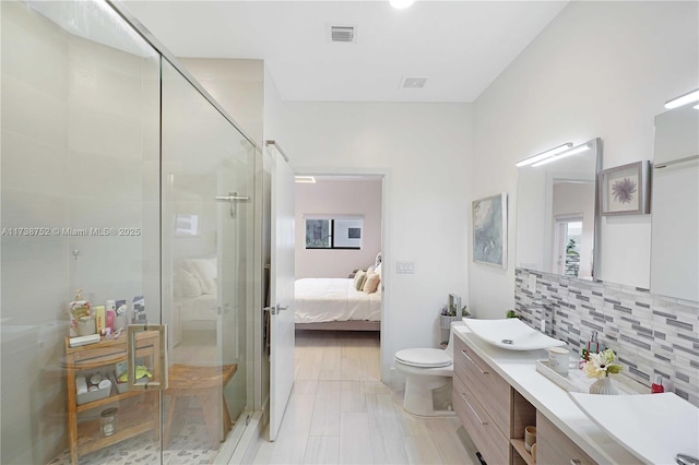 bathroom with toilet, vanity, backsplash, and walk in shower