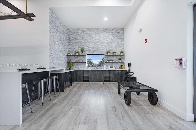 kitchen with light hardwood / wood-style flooring and a kitchen breakfast bar