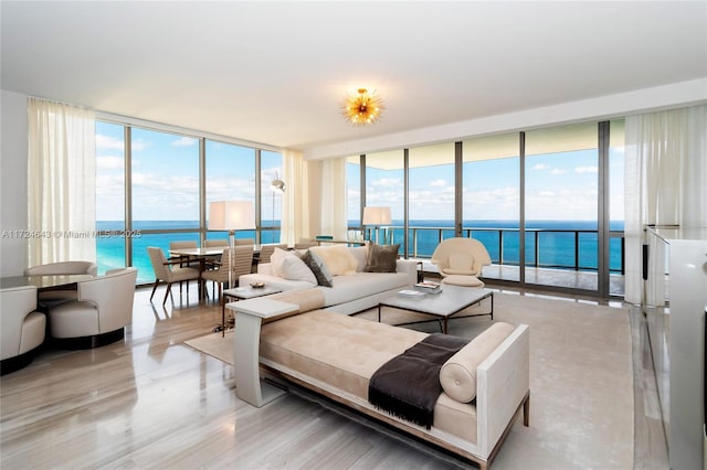 living room featuring a water view, a wall of windows, and light hardwood / wood-style floors