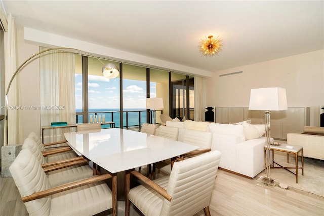 dining area featuring a water view and light hardwood / wood-style flooring