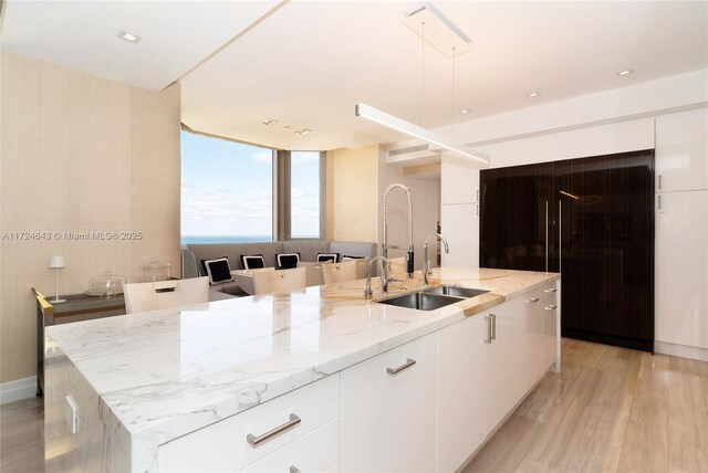 kitchen featuring sink, white cabinets, and a spacious island