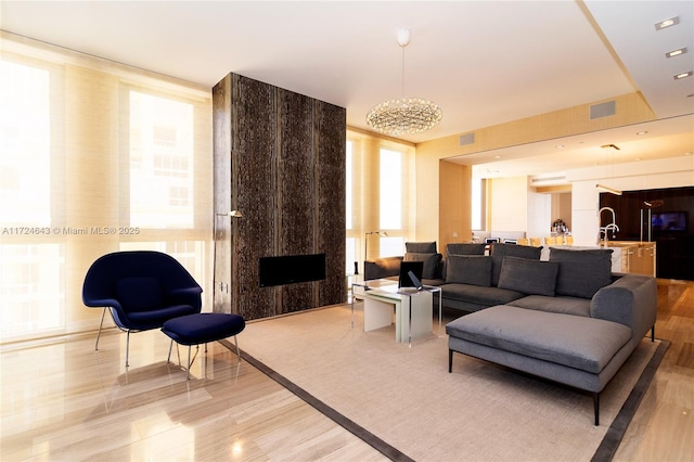 living room featuring sink, a fireplace, and a wall of windows