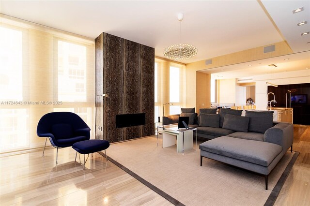 living room featuring sink, a fireplace, and a wall of windows