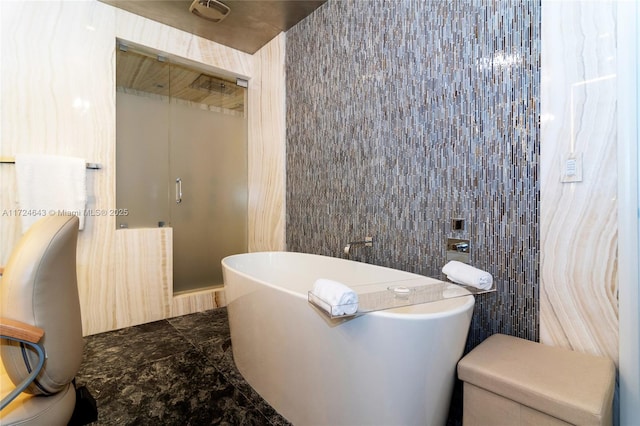 bathroom with tile walls and a bathtub