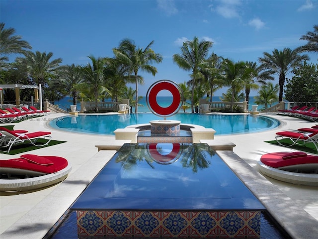 view of pool featuring a patio area and a water view