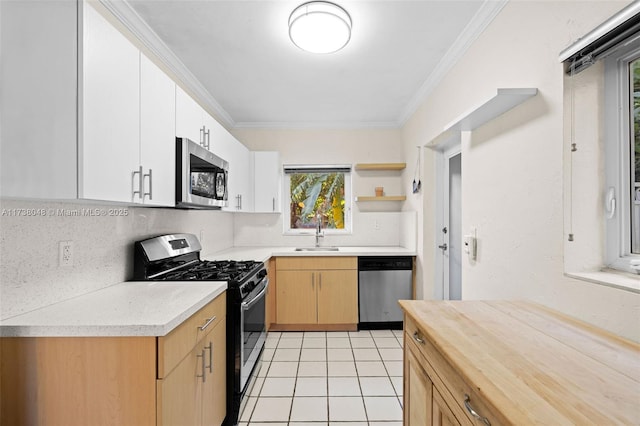 kitchen with stainless steel appliances, crown molding, sink, and white cabinets