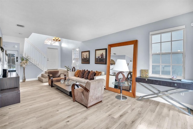 living room with an inviting chandelier and light hardwood / wood-style floors