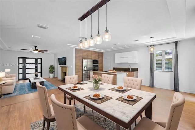 339 NE 100th St, Miami Shores, FL 33138 - dining room with light wood-style floors, a ceiling fan, baseboards, and a fireplace