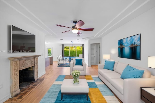 339 NE 100th St, Miami Shores, FL 33138 - living area featuring a ceiling fan, wood finished floors, baseboards, and a fireplace
