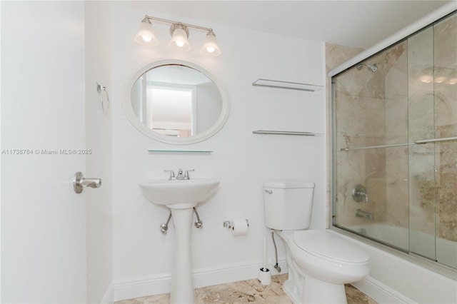 bathroom featuring bath / shower combo with glass door and toilet