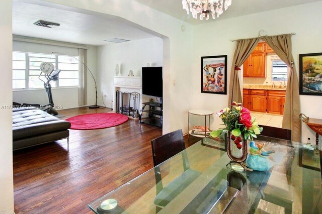 dining area with dark wood-type flooring and an inviting chandelier