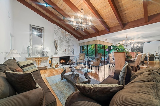 living room with a notable chandelier, beam ceiling, a high end fireplace, and hardwood / wood-style floors