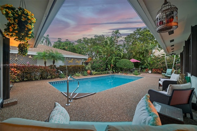 pool at dusk featuring a patio area