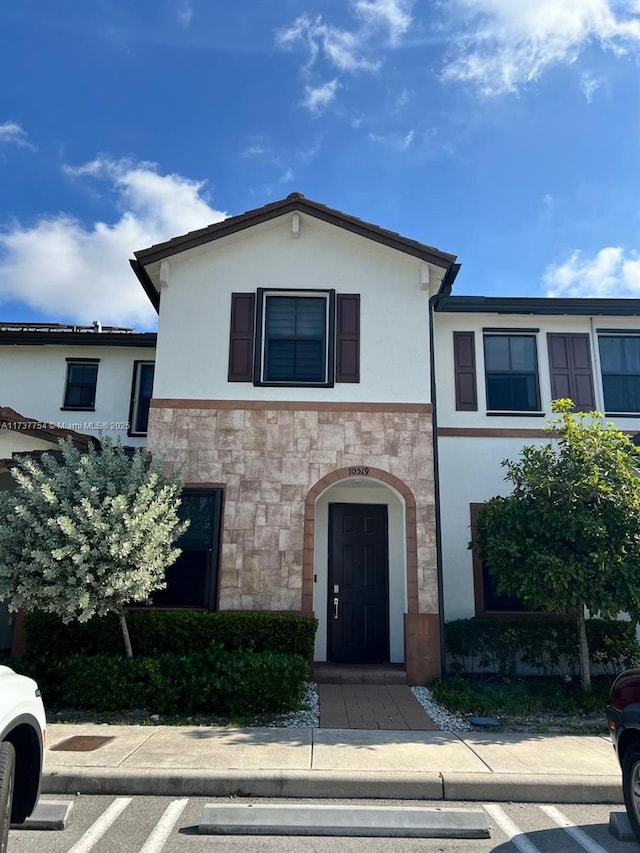 10519 W 33rd Ct Unit 10519, Hialeah, FL 33018 - view of front of home with stucco siding, stone siding, and uncovered parking