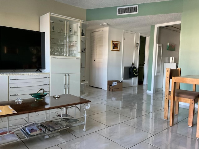 tiled living room with a textured ceiling