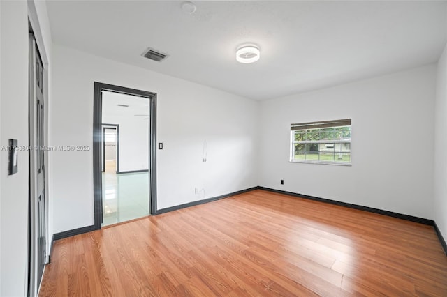 unfurnished room with hardwood / wood-style flooring