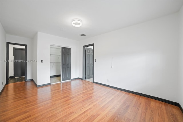 unfurnished bedroom with a closet and light wood-type flooring