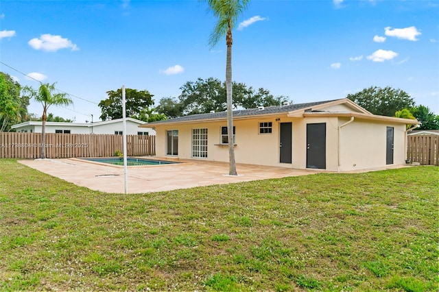 back of property with a lawn and a patio area