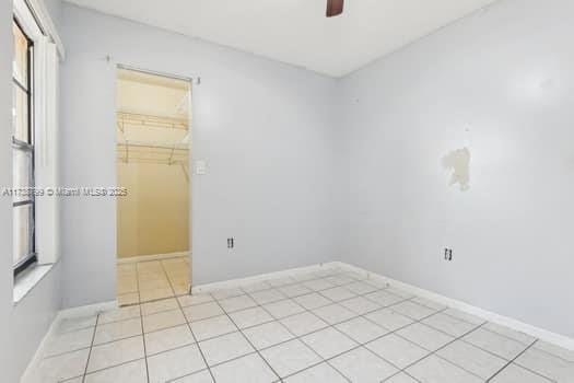 unfurnished room with baseboards and light tile patterned floors