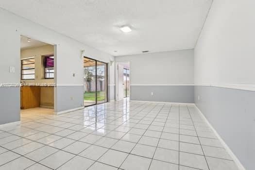 unfurnished room with light tile patterned flooring and baseboards