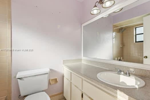 full bathroom featuring vanity, toilet, and walk in shower