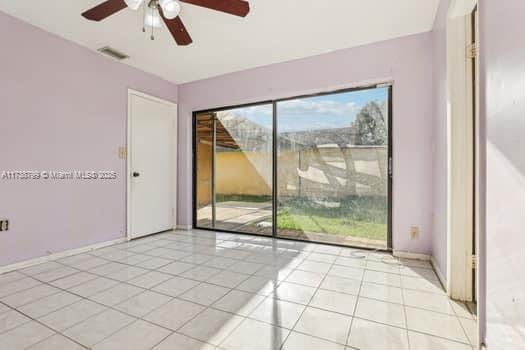 unfurnished room with light tile patterned floors, baseboards, visible vents, and ceiling fan