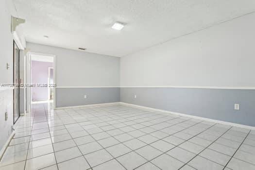 unfurnished room featuring baseboards and light tile patterned flooring