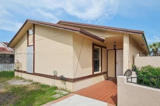 view of side of property with fence and stucco siding