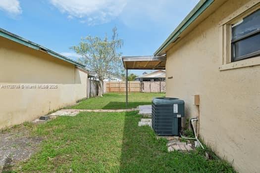 view of yard with cooling unit and fence