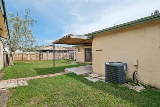 view of yard with a fenced backyard and central AC