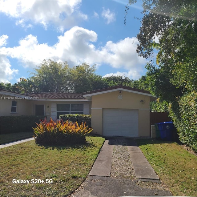 single story home with a garage and a front yard