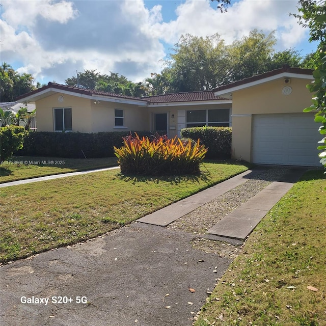 single story home featuring a garage and a front yard