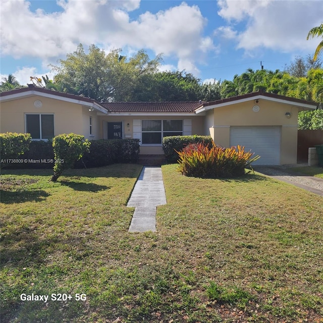 single story home featuring a garage and a front lawn