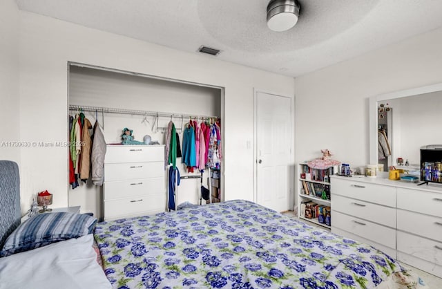 bedroom featuring ceiling fan, a closet, and a textured ceiling