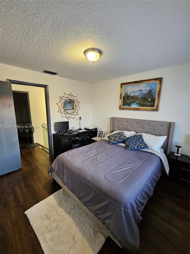 bedroom featuring dark hardwood / wood-style floors and a textured ceiling