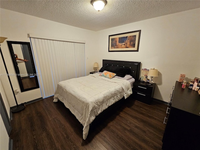 bedroom featuring dark hardwood / wood-style flooring and a textured ceiling