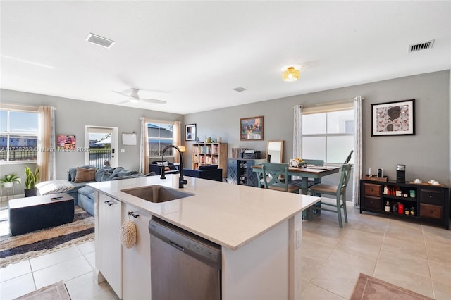 kitchen with sink, a center island with sink, light tile patterned floors, stainless steel dishwasher, and ceiling fan