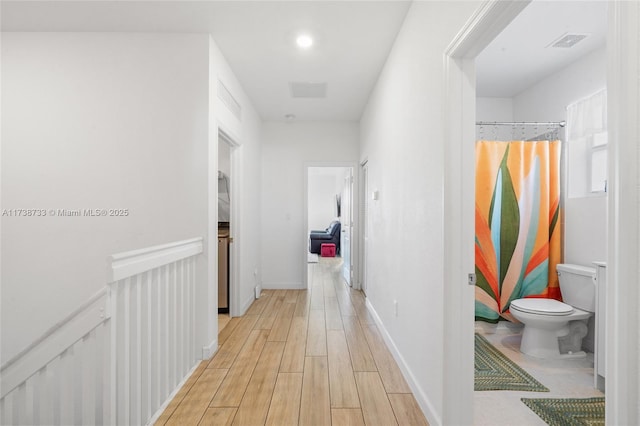 hallway with light hardwood / wood-style floors