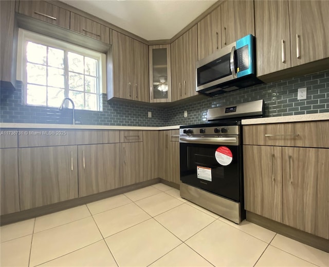 kitchen with tasteful backsplash, appliances with stainless steel finishes, and light tile patterned floors