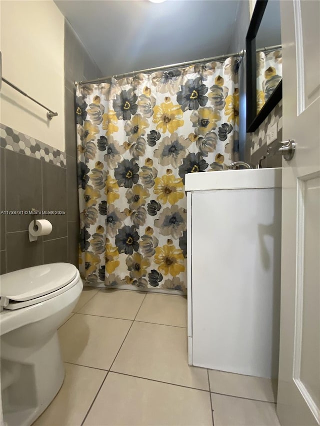 bathroom with tile patterned flooring, walk in shower, tile walls, and toilet