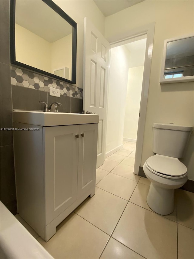 bathroom featuring tile patterned floors, toilet, decorative backsplash, and vanity