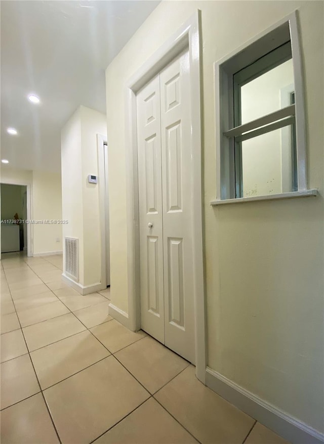 corridor with light tile patterned floors