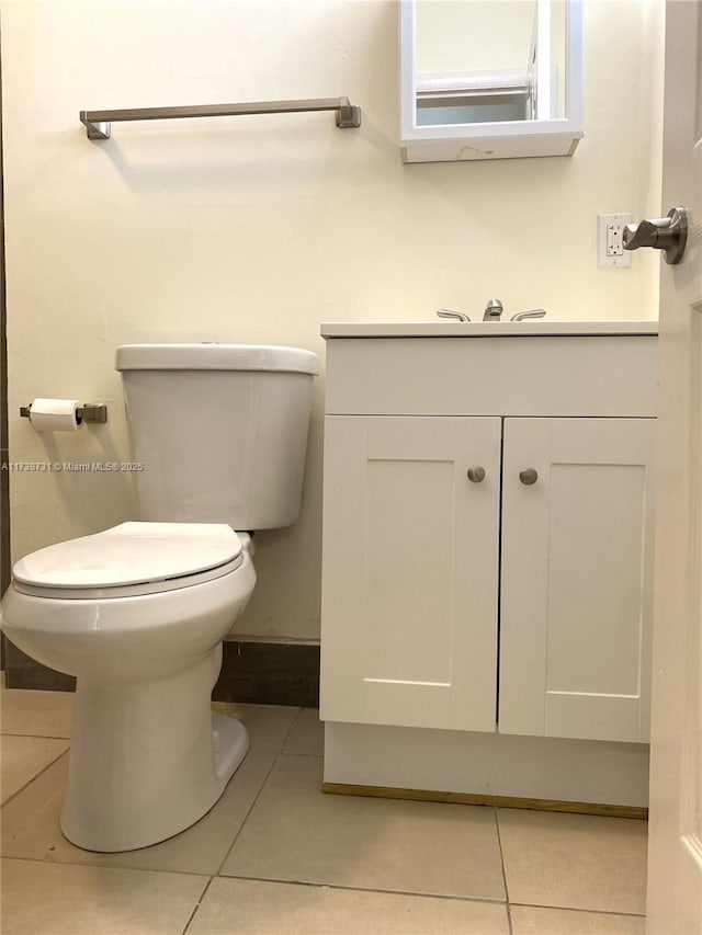 bathroom featuring vanity, tile patterned floors, and toilet