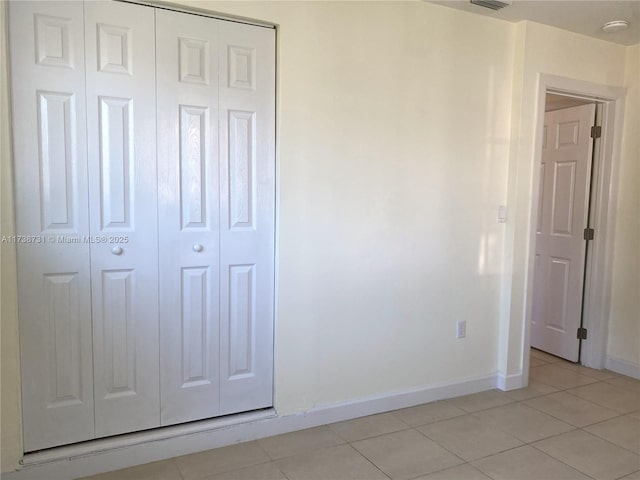 unfurnished bedroom with light tile patterned floors and a closet