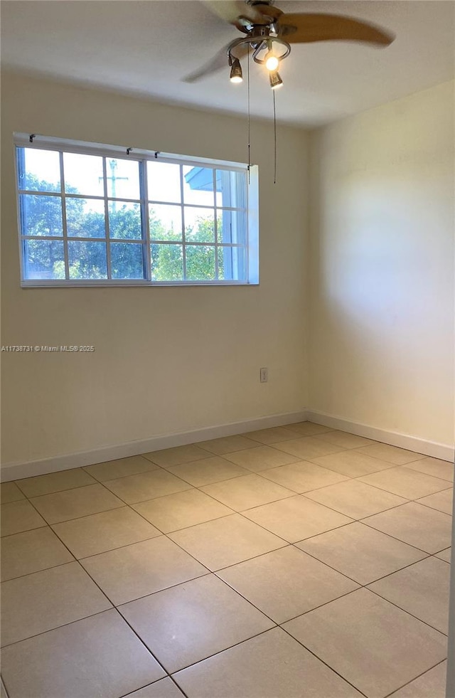 tiled spare room featuring ceiling fan and a healthy amount of sunlight