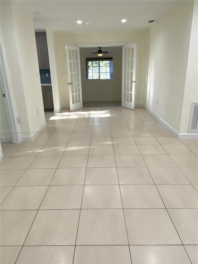 empty room with french doors, ceiling fan, and light tile patterned flooring