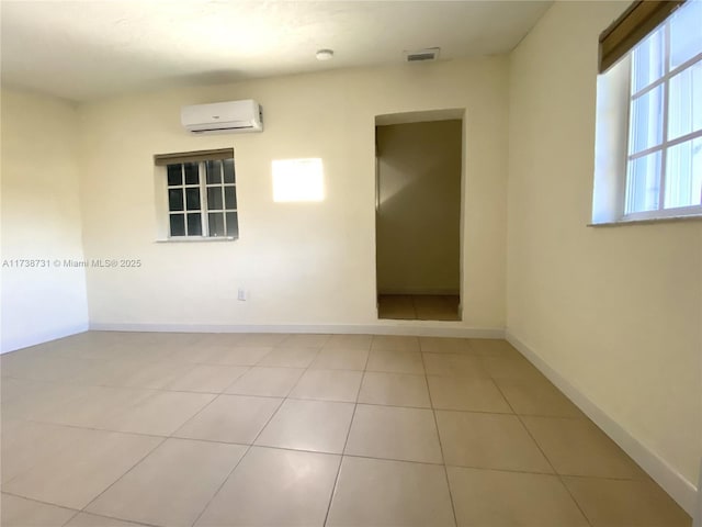 empty room with light tile patterned floors and a wall mounted AC