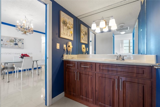 bathroom with vanity, a notable chandelier, tile patterned floors, and a textured ceiling