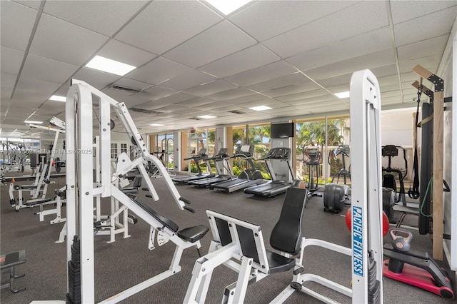 exercise room with a drop ceiling and plenty of natural light