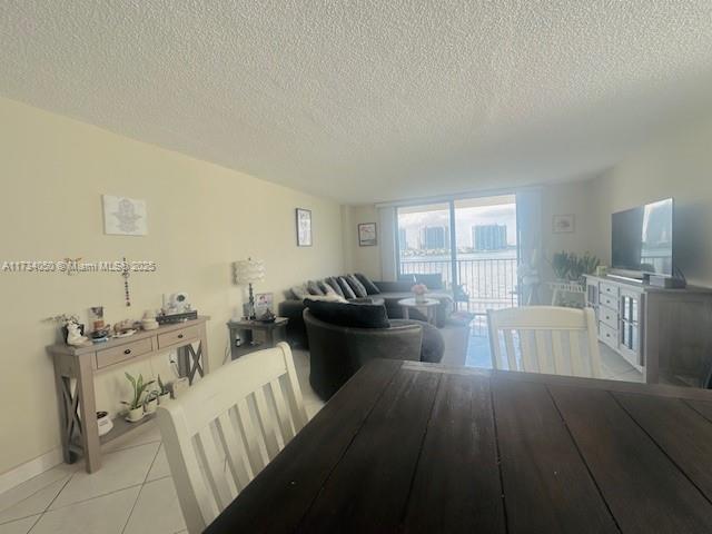 dining space with light tile patterned floors and a textured ceiling